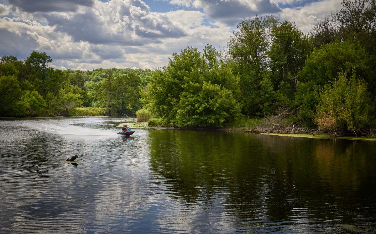 Jet ski sur riviere entouree de verdure